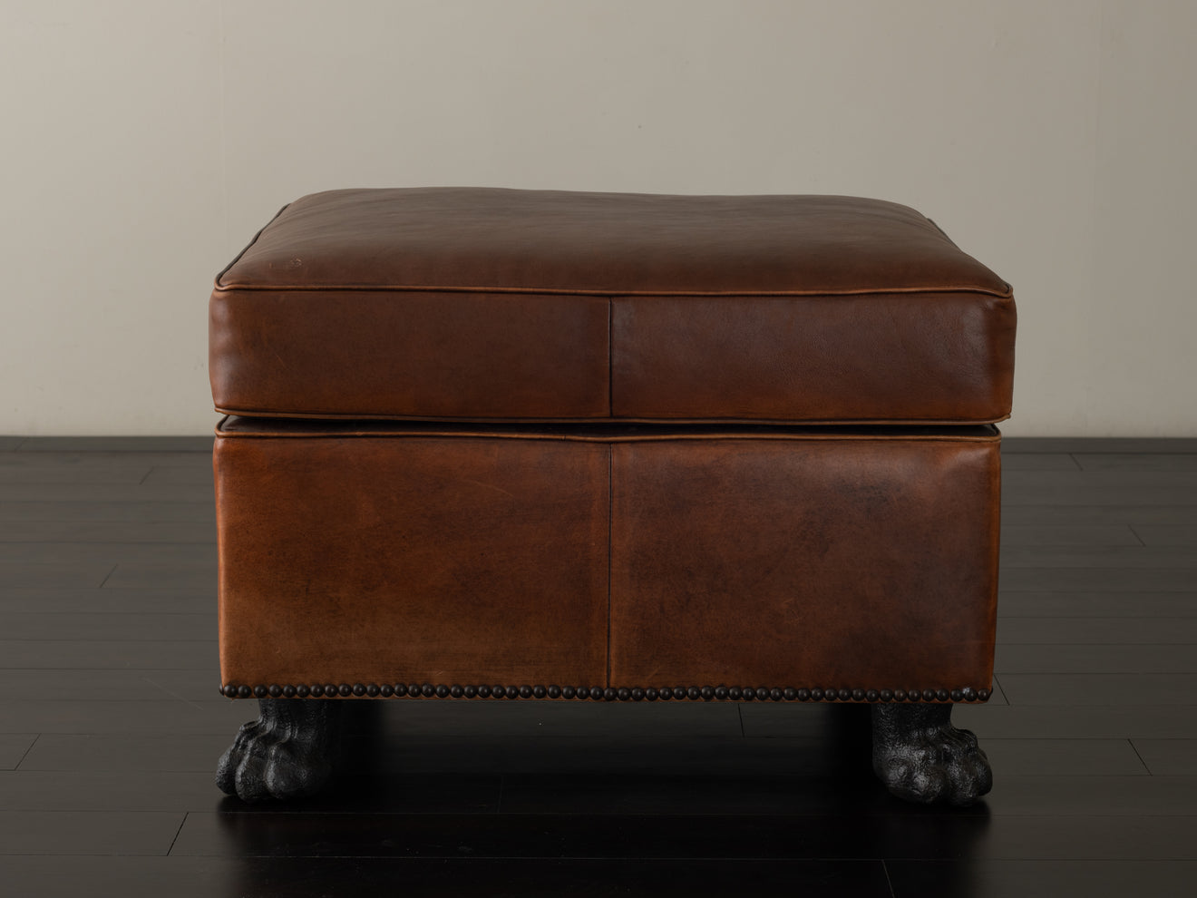 BRONZE FOOTED LEATHER OTTOMAN